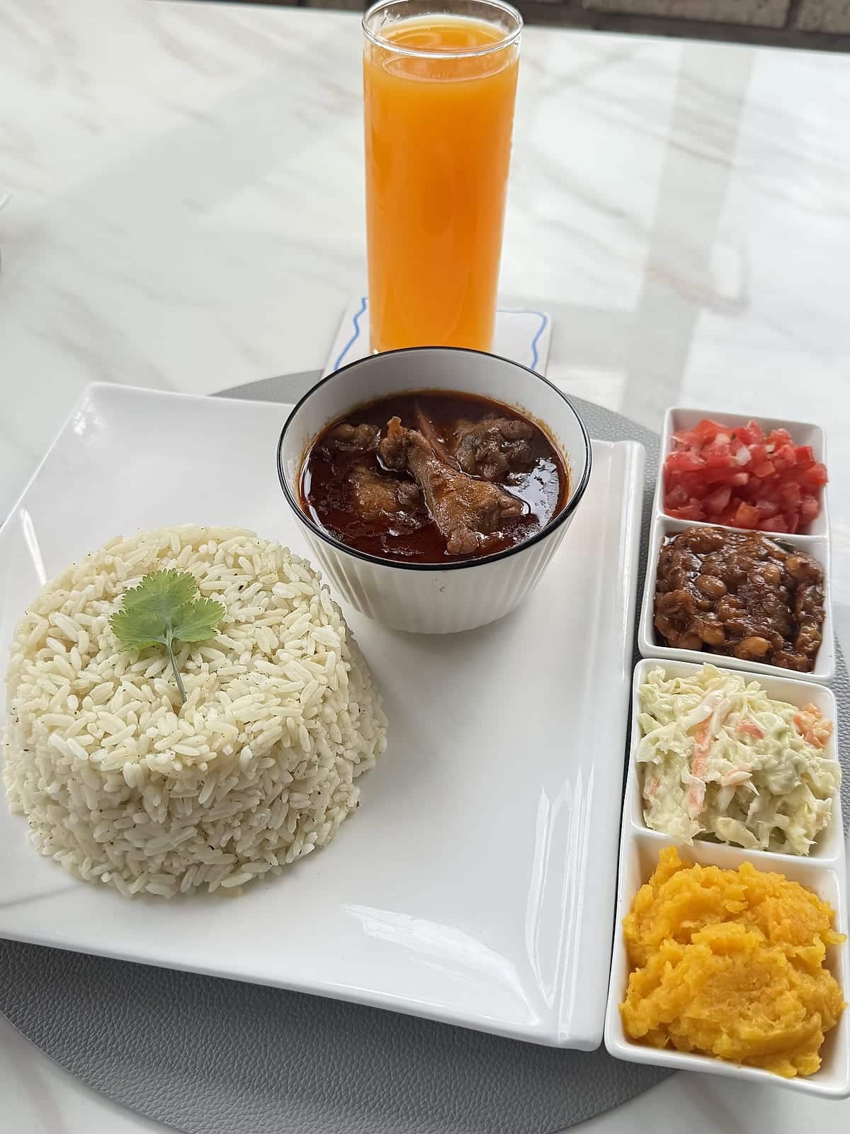 Beef stew with rice and a tray of chakalaka, coleslaw, butternut and salsa