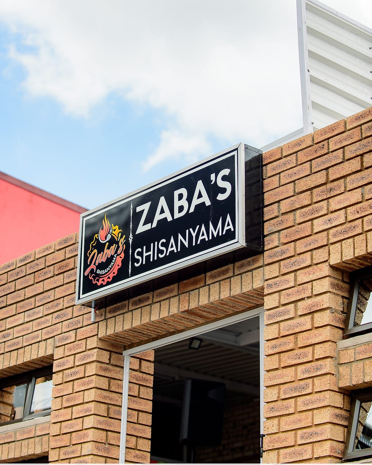 The Zaba's Shisanyama sign mounted on the brick face of the building