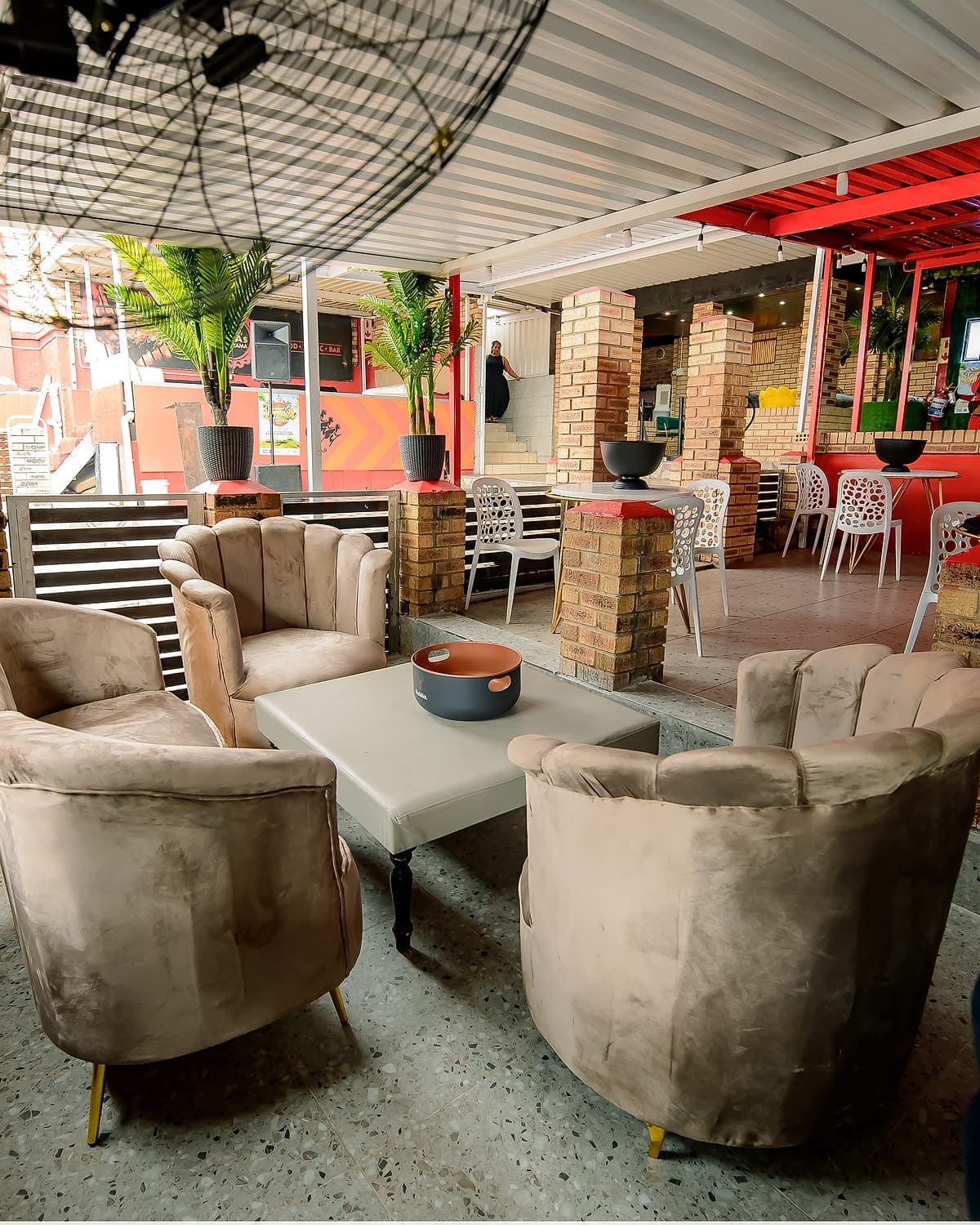Velvet tub chairs around a low table on the covered terrace at Zaba's